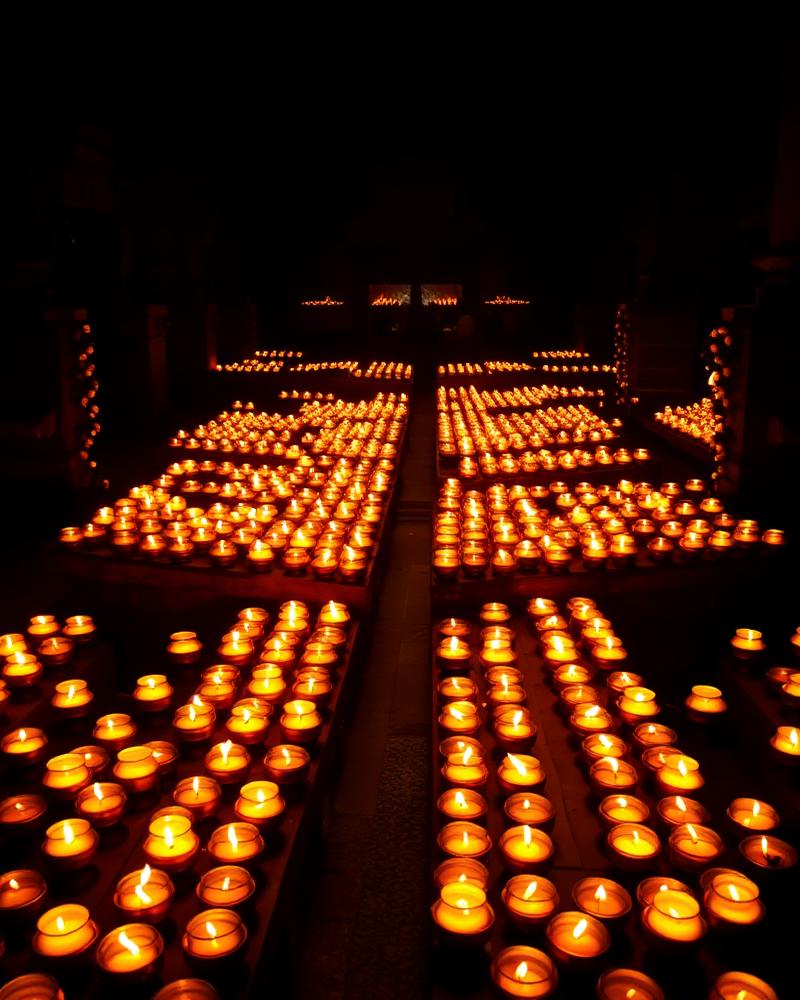 Hundreds of butter lamps lit in a temple